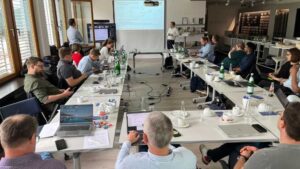 Menschen sitzen um Tische in U-Form. Meetingatmosphäre.